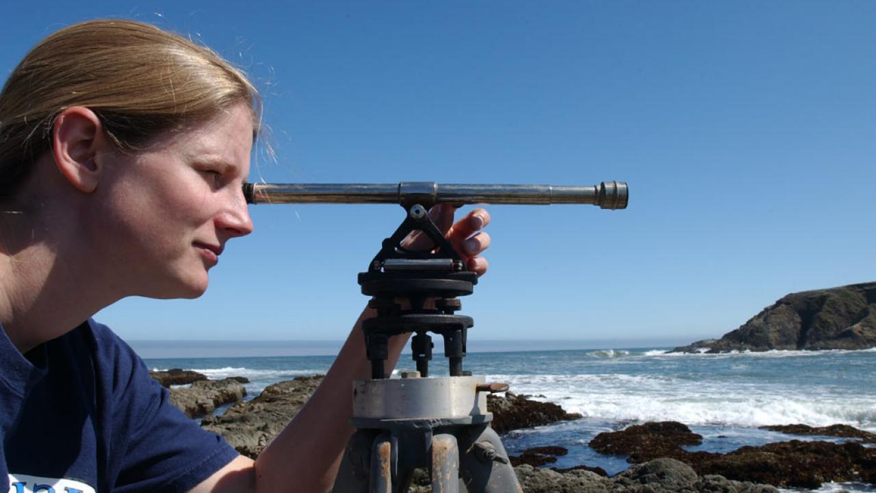 一位女性研究人员正在调查博德加湾附近的海岸线